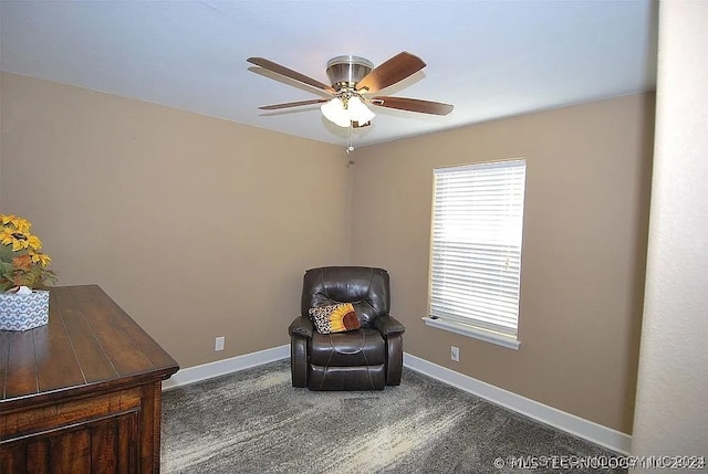 living area featuring ceiling fan and dark colored carpet