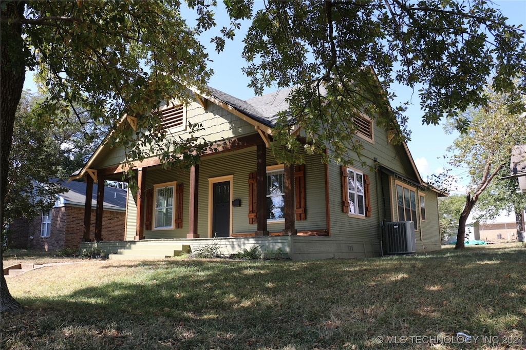 view of front of house with a porch, a front lawn, and central air condition unit