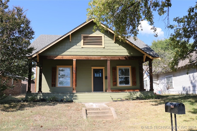 bungalow-style home featuring a front lawn and covered porch