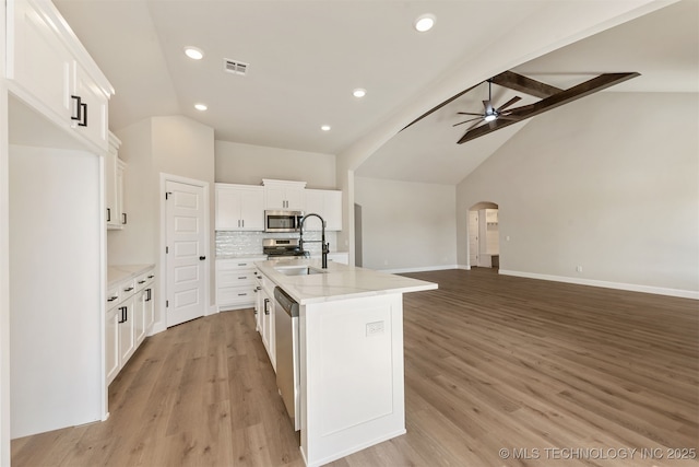 kitchen with sink, ceiling fan, white cabinetry, stainless steel appliances, and a center island with sink