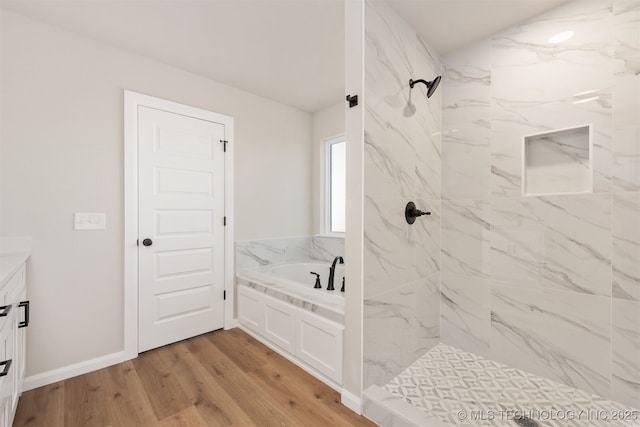 bathroom featuring vanity, hardwood / wood-style flooring, and shower with separate bathtub