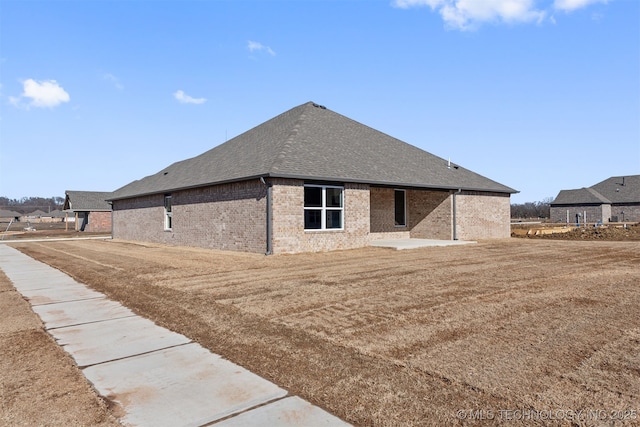 rear view of house with a yard and a patio