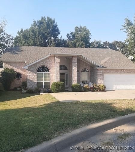 ranch-style home with a front lawn and a garage