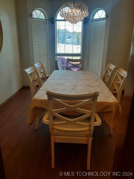 dining area featuring hardwood / wood-style floors and a notable chandelier