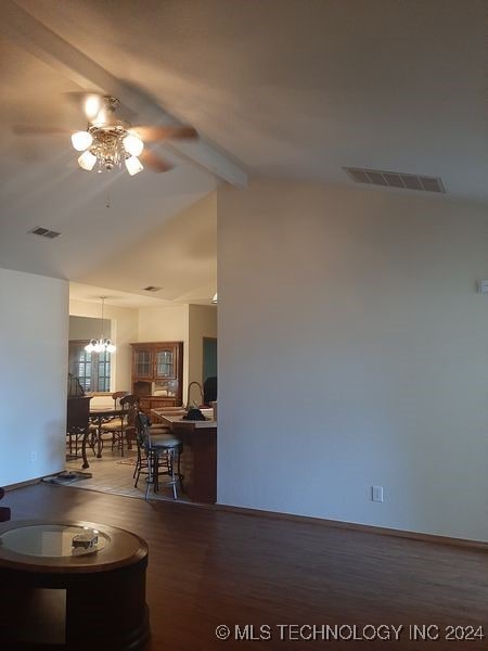 living room with wood-type flooring, ceiling fan with notable chandelier, and lofted ceiling with beams