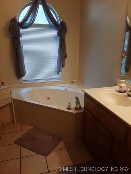 bathroom featuring a tub to relax in, tile patterned flooring, and vanity