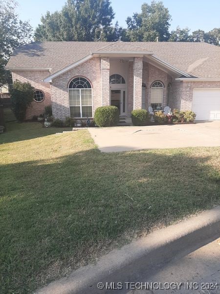 ranch-style house featuring a front yard and a garage