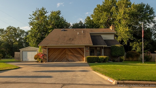 view of front of home with a front lawn, an outdoor structure, and a garage