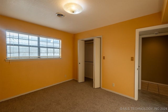 unfurnished bedroom with carpet floors and a closet