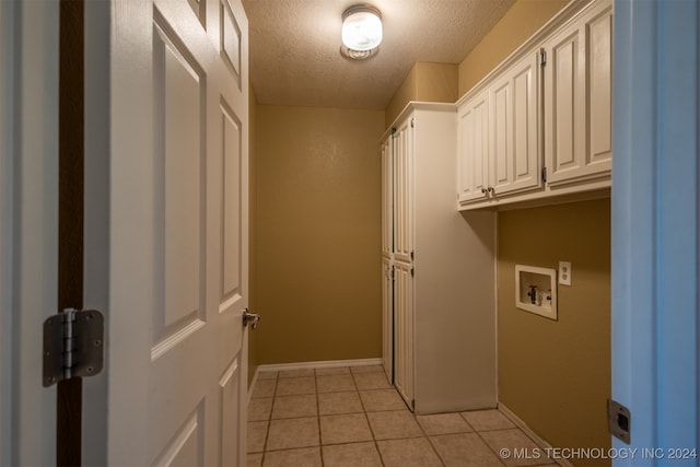 laundry room featuring hookup for a washing machine, cabinets, a textured ceiling, and light tile patterned flooring