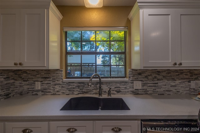 kitchen with white cabinetry, sink, and tasteful backsplash