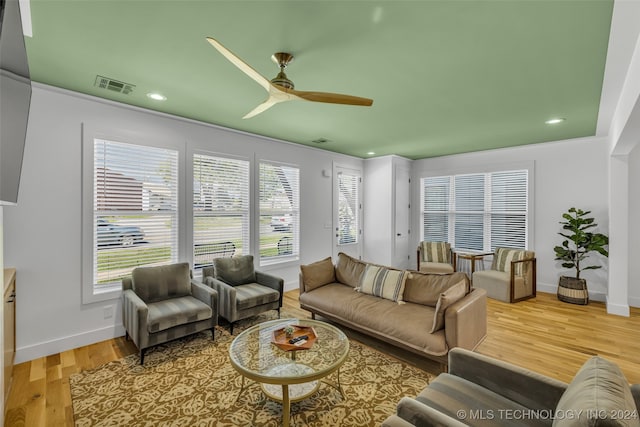 living room with light wood-type flooring, a healthy amount of sunlight, and ceiling fan