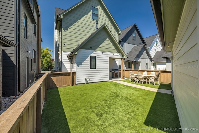 back of house featuring a yard and a patio area