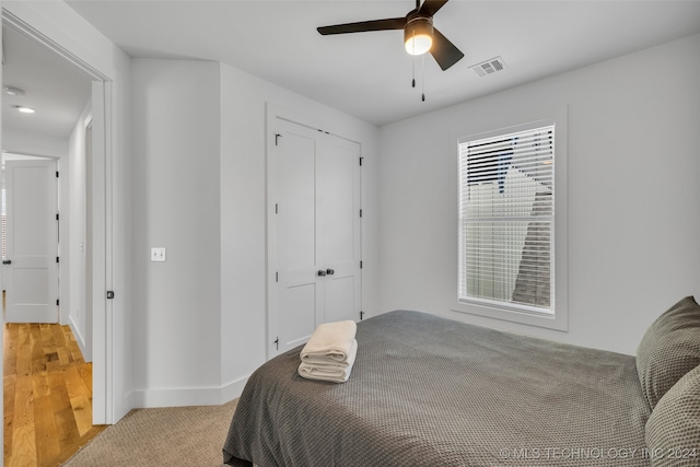 bedroom with ceiling fan, a closet, and light hardwood / wood-style floors