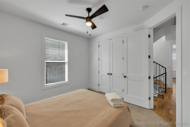 bedroom with ceiling fan, a closet, and light hardwood / wood-style flooring