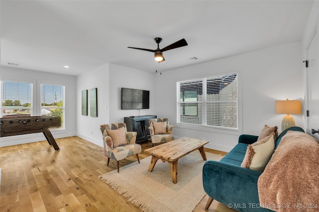 living room with light hardwood / wood-style flooring, a wealth of natural light, and ceiling fan