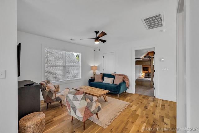 living room with ceiling fan and light wood-type flooring