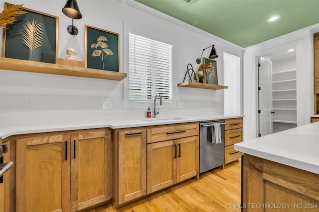 kitchen with hanging light fixtures, dishwasher, light hardwood / wood-style floors, and sink