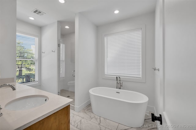 full bathroom featuring vanity, shower with separate bathtub, and toilet