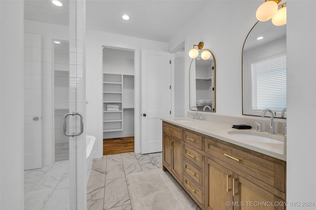 bathroom with a shower with shower door and vanity