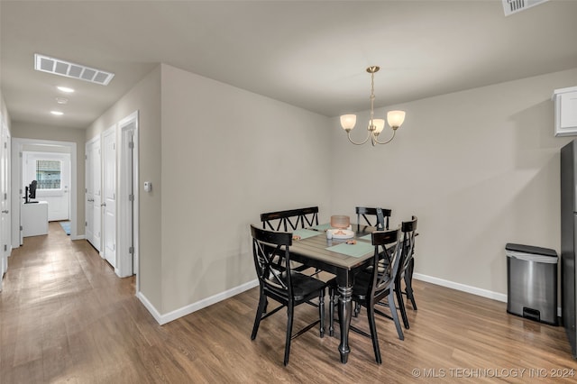 dining room with hardwood / wood-style flooring and a chandelier