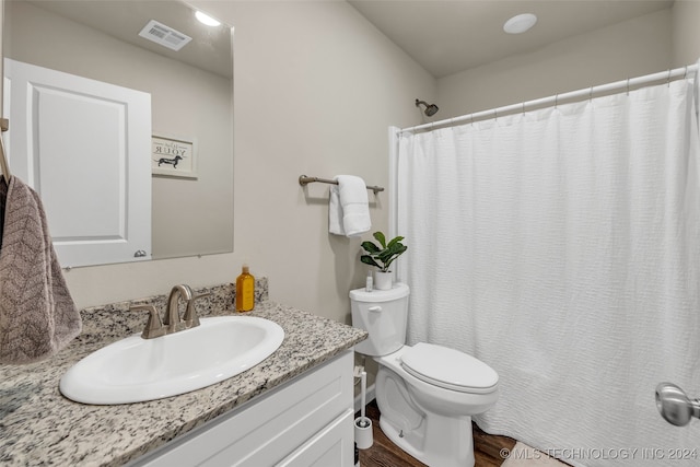 bathroom with walk in shower, vanity, toilet, and hardwood / wood-style flooring