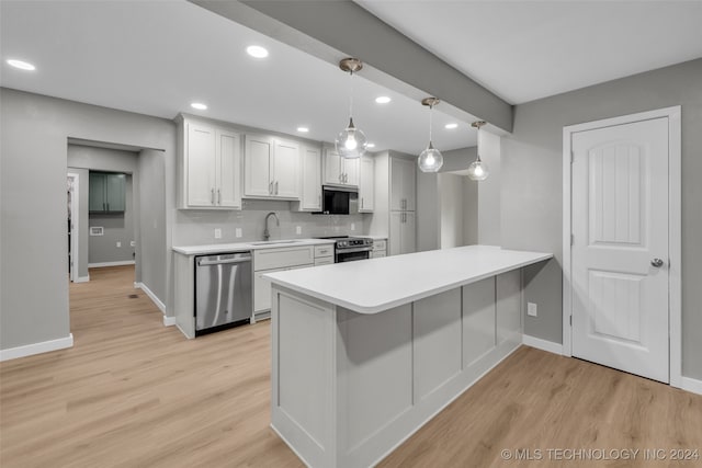 kitchen with appliances with stainless steel finishes, hanging light fixtures, light hardwood / wood-style floors, white cabinets, and sink