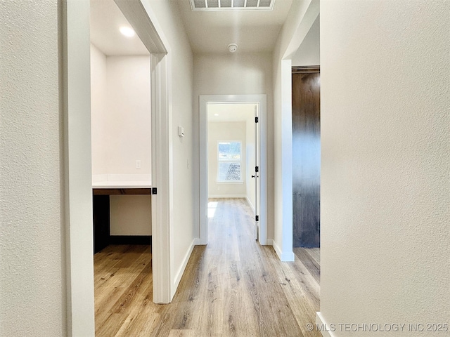 hallway with light hardwood / wood-style floors