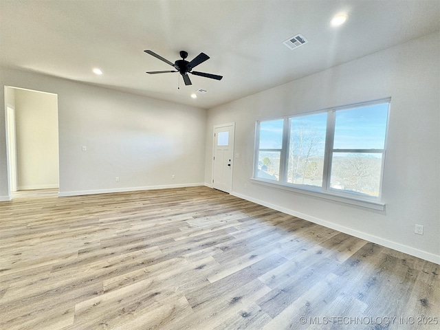 empty room with ceiling fan and light hardwood / wood-style floors