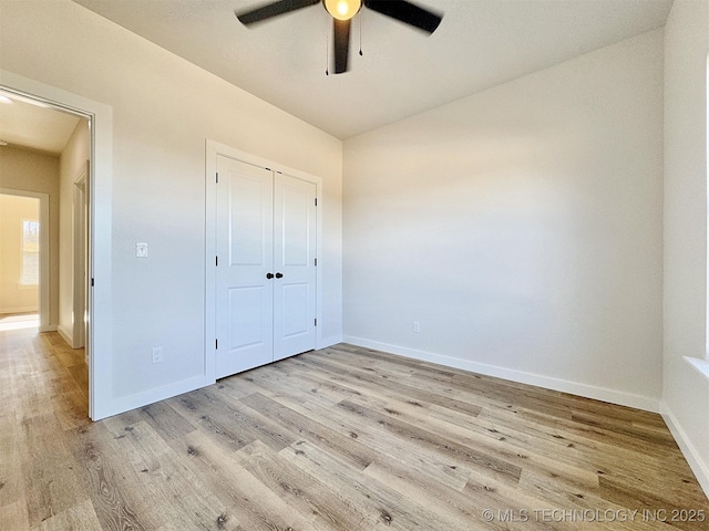 unfurnished bedroom featuring light hardwood / wood-style floors, a closet, and ceiling fan