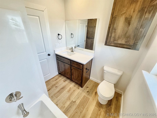 bathroom featuring wood-type flooring, toilet, and vanity