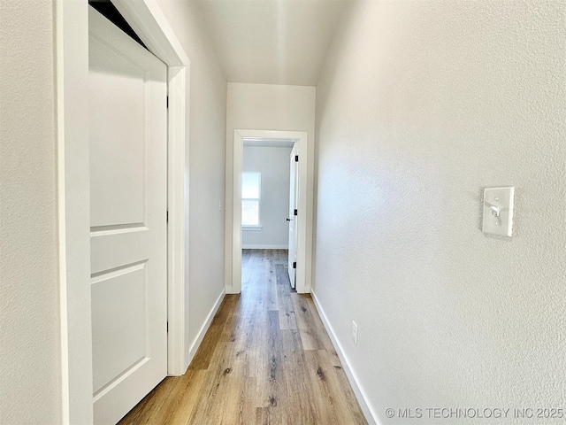 hallway with baseboards and light wood-style floors