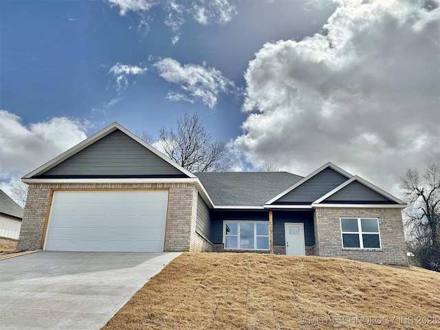 single story home featuring driveway, an attached garage, and brick siding