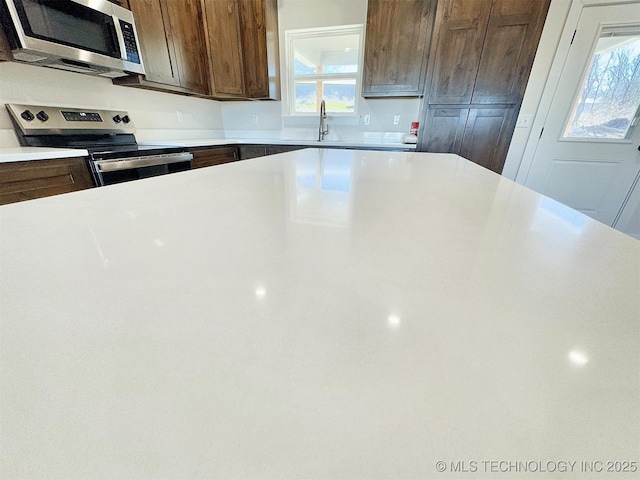 kitchen featuring a sink, stainless steel appliances, and light countertops