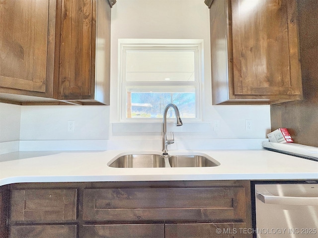 kitchen featuring light countertops, a sink, and stainless steel dishwasher