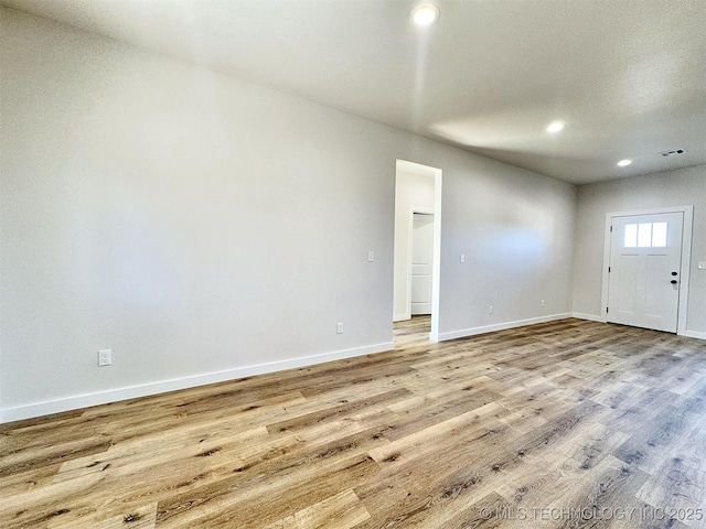 unfurnished room with recessed lighting, visible vents, baseboards, and wood finished floors