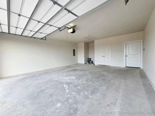 garage featuring a garage door opener, electric panel, and baseboards