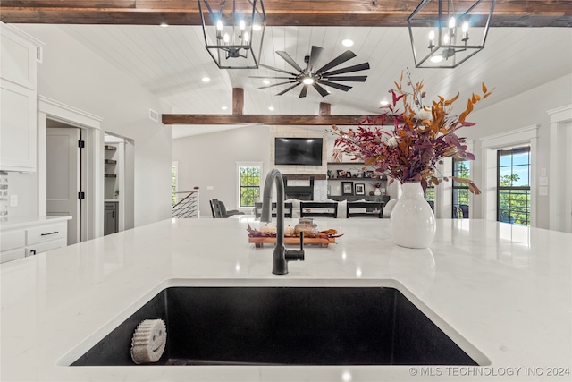 kitchen featuring vaulted ceiling with beams, decorative light fixtures, wood ceiling, and a healthy amount of sunlight