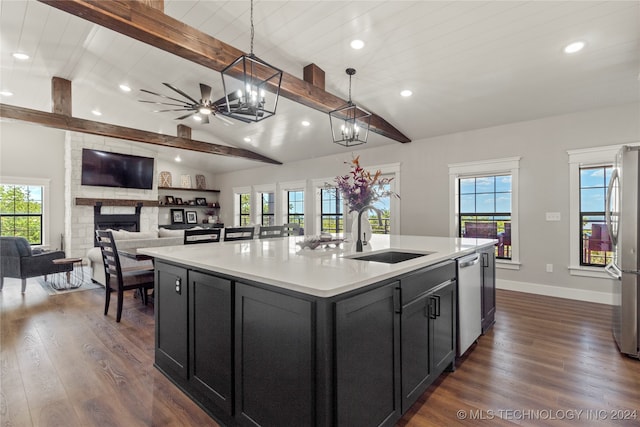 kitchen with pendant lighting, an island with sink, lofted ceiling with beams, and sink