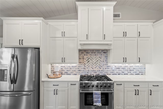 kitchen featuring white cabinetry, appliances with stainless steel finishes, tasteful backsplash, and vaulted ceiling