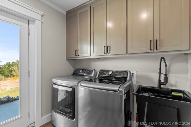 washroom featuring separate washer and dryer, ornamental molding, sink, and cabinets