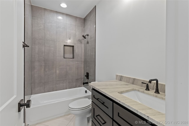 full bathroom featuring tile patterned floors, vanity, tiled shower / bath combo, and toilet