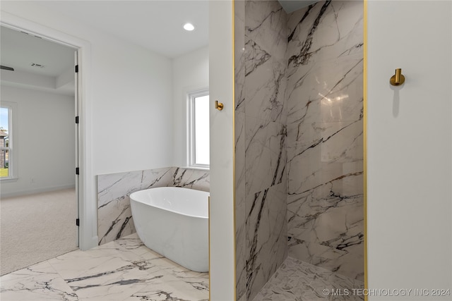 bathroom featuring a healthy amount of sunlight, tile walls, and shower with separate bathtub