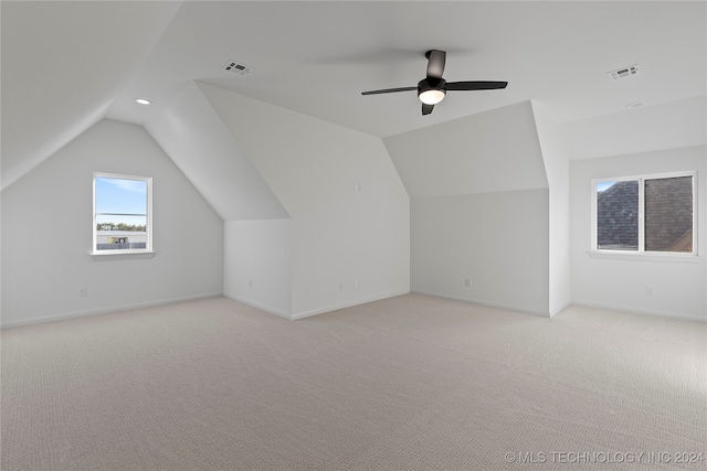 additional living space featuring light carpet, ceiling fan, and lofted ceiling