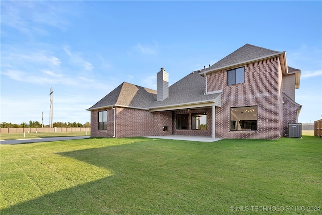 back of house with a lawn, central air condition unit, and a patio