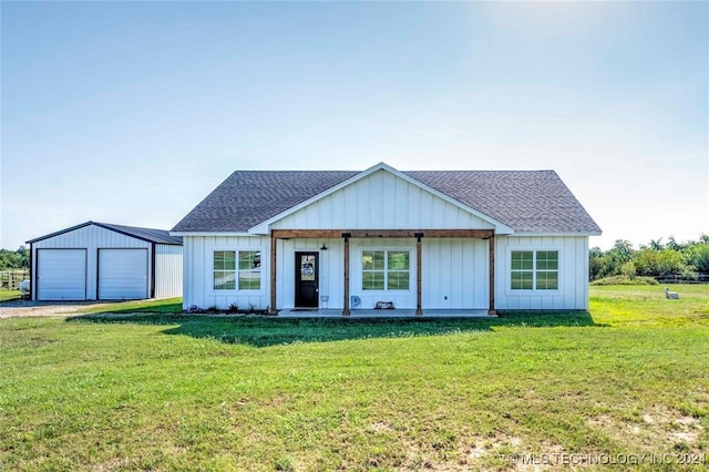 view of front of home with a garage, an outdoor structure, and a front lawn