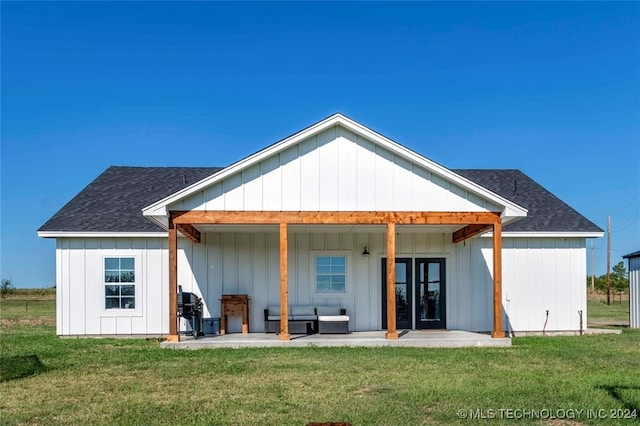 rear view of property featuring a patio area and a yard