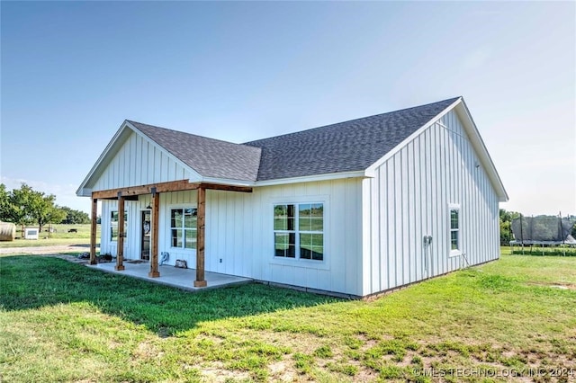 rear view of property with a yard and a patio area