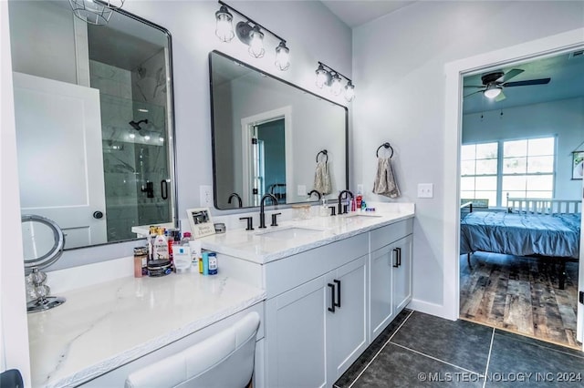 bathroom with tile patterned flooring, a shower with door, ceiling fan, and vanity