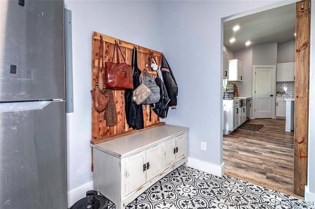 mudroom with light hardwood / wood-style flooring and vaulted ceiling